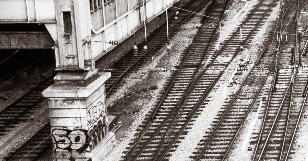 Rotaie ferroviarie viste dall'alto vicino a una stazione ferroviaria