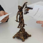 Statuetta della giustizia ed avvocati alla scrivania